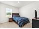 Serene bedroom with a patterned bedspread and natural light from the window at 6895 Botanic Blvd, Harmony, FL 34773