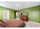 Bright bedroom boasts green walls, carpet, and a dresser with wall-mounted television at 6895 Botanic Blvd, Harmony, FL 34773