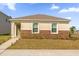 Inviting single-Gathering home featuring decorative stone accents, green door, and manicured front lawn at 6895 Botanic Blvd, Harmony, FL 34773
