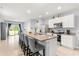 Open-concept kitchen with a large granite island and stainless steel appliances at 6895 Botanic Blvd, Harmony, FL 34773