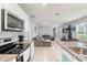 Open-concept living space featuring stainless steel appliances and a gray sectional sofa at 6895 Botanic Blvd, Harmony, FL 34773