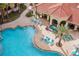 Aerial view of a resort pool with in-water loungers, surrounded by lush landscaping and a poolside pavilion at 7395 Universal Blvd # 1005, Orlando, FL 32819