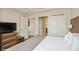 Relaxing bedroom showcasing a king-size bed, wood-grain headboard, TV, dresser, and closet space at 7395 Universal Blvd # 1005, Orlando, FL 32819