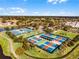 Aerial view of tennis and pickleball courts in a community surrounded by green space and ponds at 8456 Norwich Way, Mount Dora, FL 32757