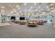 A large ballroom with tables, chairs, chandeliers, a stage and neutral carpeting at 8456 Norwich Way, Mount Dora, FL 32757