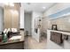 Modern bathroom featuring a glass-enclosed shower, sleek vanity with black fixtures, and neutral-toned tile at 8456 Norwich Way, Mount Dora, FL 32757