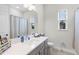 Well-lit bathroom with a modern vanity, sleek fixtures, a large mirror, and natural light from the window at 8456 Norwich Way, Mount Dora, FL 32757