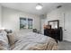 Cozy bedroom offers natural light from the window, a patterned duvet, and a dresser with a flatscreen TV at 8456 Norwich Way, Mount Dora, FL 32757