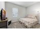 Guest bedroom with a floral comforter, comfortable carpet, and a window providing natural light at 8456 Norwich Way, Mount Dora, FL 32757