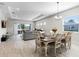Open-concept dining area with wood-look tile, modern chandelier, and a sliding glass door at 8456 Norwich Way, Mount Dora, FL 32757