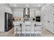 Modern kitchen with light grey cabinets, stainless appliances, backsplash, and island with seating at 8456 Norwich Way, Mount Dora, FL 32757