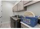 Well-equipped laundry room featuring modern washer and dryer, overhead cabinets, and a handy laundry basket at 8456 Norwich Way, Mount Dora, FL 32757