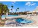 Community pool featuring a spa, lounge chairs, and palm trees creating a resort-like atmosphere at 8456 Norwich Way, Mount Dora, FL 32757