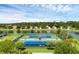 Tennis courts with a lake and homes in the background at 8456 Norwich Way, Mount Dora, FL 32757