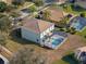 Back of home featuring a screened-in pool area, lush landscaping, and a well-maintained lawn at 9026 Paolos Pl, Kissimmee, FL 34747