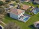 Aerial view of home showing backyard pool, screened-in patio, lush landscaping, and mature trees at 9026 Paolos Pl, Kissimmee, FL 34747