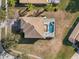 Aerial shot of a home with a large backyard, screened-in pool, and a well-maintained roof at 9026 Paolos Pl, Kissimmee, FL 34747