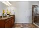 Bathroom with double vanity, granite countertop, decorative flowers, and tiled glass shower enclosure at 9026 Paolos Pl, Kissimmee, FL 34747
