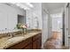 Bathroom featuring double sinks with granite countertops, vanity lighting, and a closet in the hallway at 9026 Paolos Pl, Kissimmee, FL 34747