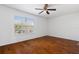 Bedroom featuring hardwood floors, a ceiling fan, and a window overlooking the backyard at 9026 Paolos Pl, Kissimmee, FL 34747