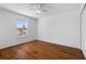 Bedroom with hardwood floors, ceiling fan, large window, and a spacious closet at 9026 Paolos Pl, Kissimmee, FL 34747