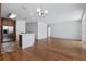 Open floor plan with hardwood floors flowing from living area to kitchen with breakfast bar at 9026 Paolos Pl, Kissimmee, FL 34747
