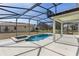 Screened-in pool area features pool, hot tub, and a covered lanai with backyard views at 9026 Paolos Pl, Kissimmee, FL 34747