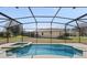Screened-in pool area features pool, hot tub, and a covered lanai with backyard views at 9026 Paolos Pl, Kissimmee, FL 34747