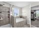 Bright bathroom showcasing tiled shower, soaking tub, and a peek into an adjacent bedroom at 9862 Pecan Hickory Way, Orlando, FL 32832