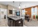 Kitchen island with granite countertop, stainless steel sink, and modern pendant lighting over looking eat-in dining area at 9862 Pecan Hickory Way, Orlando, FL 32832
