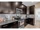 Kitchen close-up with granite countertops, stainless steel appliances and dark cabinets at 9862 Pecan Hickory Way, Orlando, FL 32832