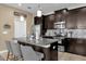 Modern kitchen featuring dark cabinets, stainless steel appliances and granite countertop on island at 9862 Pecan Hickory Way, Orlando, FL 32832