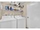 Functional laundry room with washer, dryer, and shelving for storage at 1017 Bluejack Oak Dr, Oviedo, FL 32765