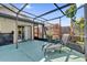 A screened-in patio with a lounge chair, grill, and native plants at 1017 Bluejack Oak Dr, Oviedo, FL 32765