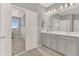 Bathroom featuring gray cabinets, quartz countertop, dual sinks, and modern fixtures at 10319 Austrina Oak Loop, Winter Garden, FL 34787