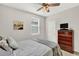 Cozy bedroom featuring a comfortable bed, ceiling fan, and dresser with television at 10319 Austrina Oak Loop, Winter Garden, FL 34787