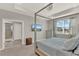 This bedroom features a four-poster bed, a window, and a gray dresser at 10319 Austrina Oak Loop, Winter Garden, FL 34787