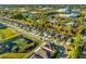 Aerial view of homes in a neighborhood bordering a pond with vibrant green trees, grass, and serene views at 1208 Patterson Ter, Lake Mary, FL 32746