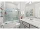 Well-appointed bathroom featuring a shower-tub combo with glass doors, a gray vanity, and modern fixtures at 1208 Patterson Ter, Lake Mary, FL 32746