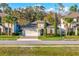 Charming home exterior with brick driveway, manicured lawn, mature palms, and a two-car garage at 1208 Patterson Ter, Lake Mary, FL 32746