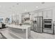 Modern kitchen featuring stainless steel appliances, island with a breakfast bar, and gray cabinetry at 1208 Patterson Ter, Lake Mary, FL 32746