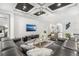 Open-concept living room with tray ceiling, modern furnishings, and seamless flow to other living spaces at 1208 Patterson Ter, Lake Mary, FL 32746