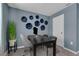 Serene home office with blue walls, decorative wall plates, and a modern black desk at 1337 Fan Palm Dr, Davenport, FL 33897