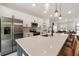 Modern kitchen featuring stainless steel appliances, white cabinets, quartz countertops, and pendant lighting at 16074 Sw 49Th Court Rd, Ocala, FL 34473