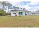 A view of the backyard showing the patio, grill and the house's white exterior at 1660 5 Ave, Deland, FL 32724