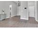 Bright hallway with hard surface floors, a modern light fixture, and neutral paint, leading to other rooms at 1660 5 Ave, Deland, FL 32724