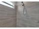 Modern tiled shower features neutral tile, window, and updated shower head at 1660 5 Ave, Deland, FL 32724