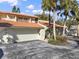 Exterior view of townhomes with terracotta roofs, two car garages, and tropical landscaping at 176 Balfour Dr # 4, Winter Park, FL 32792