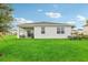 View of the home's backyard showcasing a covered patio and expansive lawn space at 1851 Columbus Path, St Cloud, FL 34771