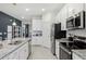 Well-lit kitchen featuring stainless steel appliances, granite countertops, and white cabinetry at 1851 Columbus Path, St Cloud, FL 34771